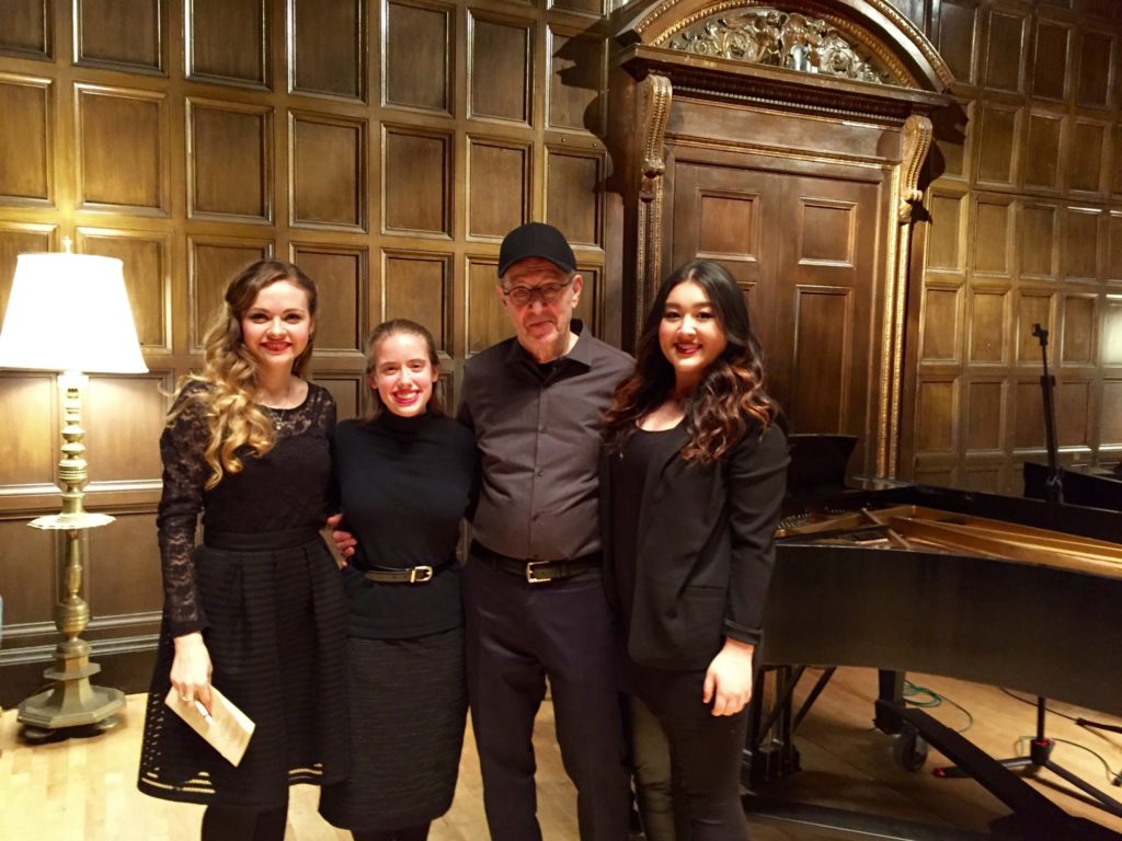 Violinist Holly Workman smiling on stage with composer Steve Reich and two other musicians after a concert